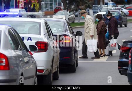 Bukarest, Rumänien - 14. April 2020: Alte Menschen mit Maske sind zurück vom Einkaufen. Rumänien ist wegen des Coronavirus in der Blockierung und die älteren Menschen sind alle Stockfoto