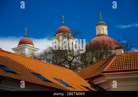 Kirche Kuppeln mit Kreuzen und roten Ziegeldächern und blauen Himmel auf dem Hintergrund, Vilnius, Litauen Stockfoto