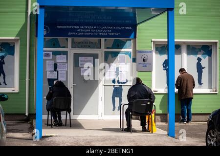 Sofia, Bulgarien. 15. April 2020. Arbeitslose, die Schutzmaske tragen, warten und füllen Formulare auf spontanen sozialen Distanzierungstabellen vor einem lokalen Arbeitszentrum der Abteilung für Sozialschutz aus. Die Arbeitslosigkeit im Land ist auf 7% wegen des Pandemischen Coronavirus Covid gestiegen - 19 nach Jahren stabil niedriger Raten bei rund 3.5%. Stockfoto