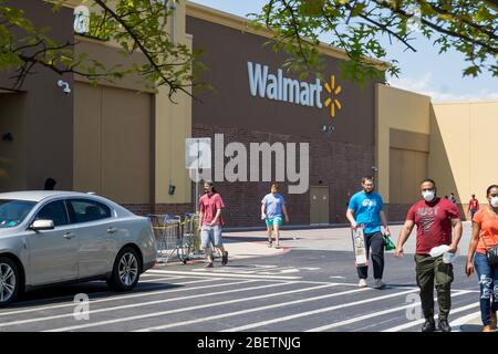 Kennesaw, GA / USA - 04/05/20: Walmart Linie vor dem Geschäft mit maskierten Menschen üben soziale Distanz 6 Fuß auseinander während Covid-19 Corona Viru Stockfoto