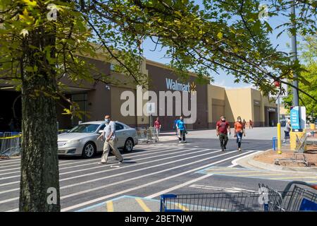 Kennesaw, GA / USA - 04/05/20: Walmart Linie vor dem Geschäft mit maskierten Menschen üben soziale Distanz 6 Fuß auseinander während Covid-19 Corona Viru Stockfoto