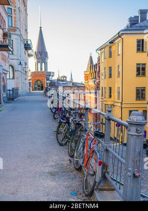 Reihe geparkter Fahrräder, Fahrräder in der Nähe von Geländer in Sodermalm Inselviertel mit traditionellen typischen Gebäuden, Stockholm, Schweden Stockfoto