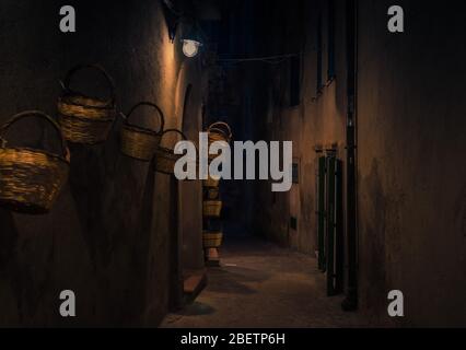 Nacht Abend Straße mit hellen Laternen Lampen und Körbe an der Wand des Gebäudes, Tropea Stadt, Vibo Valentia, Kalabrien, Süditalien Stockfoto