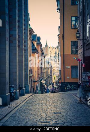 Traditionelle typische enge Straßen mit Pflastersteinen, Kopfsteinpflaster, Lampen, Cafés, Restaurants, Geschäfte, Fahrräder im alten historischen Stadtquartier Gamla Stan Stockfoto