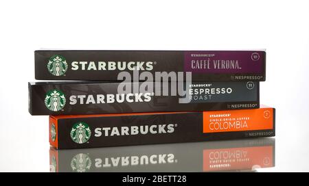 Eine Auswahl an Starbucks Kaffee Nespresso Boxen in verschiedenen Geschmacksrichtungen auf weißem Hintergrund mit Reflektion. Stockfoto