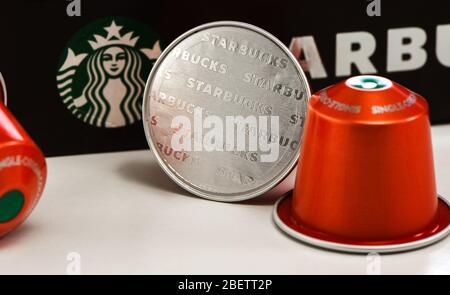 Starbucks Nespresso Box und Kapseln auf weißem Hintergrund. Nahaufnahme, um Starbucks Buchstaben auf Folie zu zeigen. Stockfoto