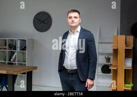 Geschäftsmann im Büro. Gutaussehender Geschäftsmann in formeller Kleidung, der Kamera im Büro ansieht. Übergewichtige Büroangestellte am Arbeitsplatz. Müssen Sie tun Stockfoto