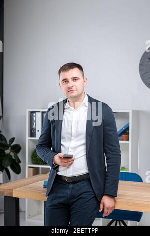 Geschäftsmann im Büro. Gutaussehender Geschäftsmann in formeller Kleidung, der Kamera im Büro ansieht. Übergewichtige Büroangestellte am Arbeitsplatz. Müssen Sie tun Stockfoto