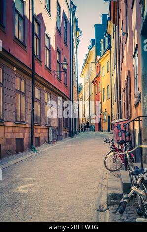 Traditionelle typisch schwedische schmale Straße mit Pflastersteinen, Fahrräder und bunten Gebäuden in alten historischen Stadtviertel Gamla Stan von Stadsholmen isl Stockfoto