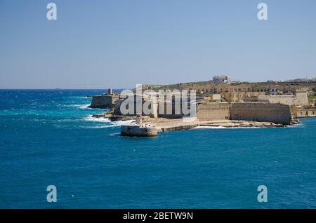 Blick auf den Hafen Eingang und alte mittelalterliche Ricasoli East Breakwater und Fort Ricasoli von Valletta, Malta Stockfoto