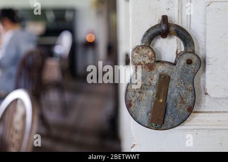 Ausgewählte Fokus und Nahaufnahme von alten rostigen Vintage Retro-Design des Schlosses hängen auf weißen Holztür. Stockfoto