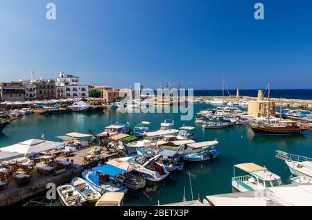 Panoramablick von der alten Burg von Marina Hafen und Hafen mit Yachten in Kyrenia Girne Stadt gegen blauen Himmel und Berge, Nordzypern Stockfoto