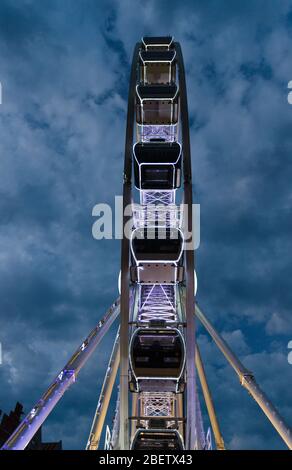 Großes leuchtendes Riesenrad vor dunkelblauem dramatischen Himmel Hintergrund am Abend in der Nacht, Danzig, Pommern, Polen Stockfoto