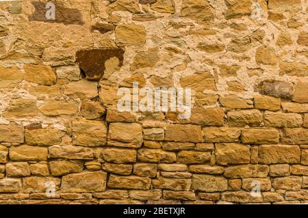 Helle Sandsteinwand mit dunklem Stein oben nicht verfugt Nahaufnahme Stockfoto
