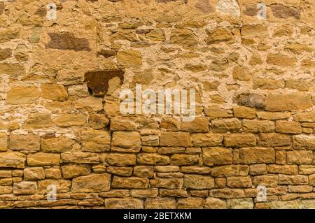 Helle Sandsteinwand mit dunklem Stein an der Spitze nicht verfugt Stockfoto