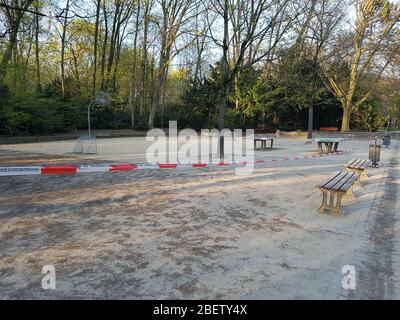 Leerer, verlassener Sportplatz mit Basketballkorb und Tischtennis, geschlossen durch Polizeischutzband wegen Corona-Virus Covid-19 Stockfoto