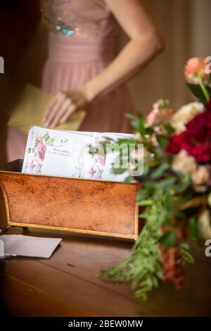 Hochzeitskarte Ankündigungen in einem dekorativen Behälter am Eingang einer Hochzeitszeremonie Flur mit Drehbuch-Schrift und Blumen verziert Stockfoto