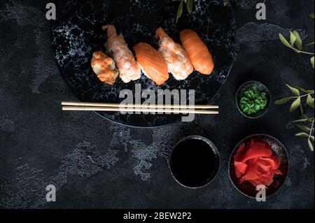Köstliches Sushi-Set auf dunklem Steinschiefer. Schwarzer Hintergrund Stockfoto