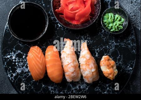 Köstliches Sushi-Set auf dunklem Steinschiefer. Schwarzer Hintergrund Stockfoto