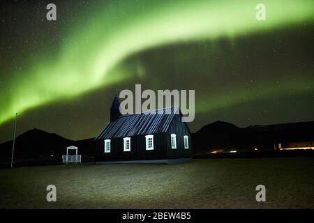 Budir, Island - Nov 27, 2019: Lange Belichtung während der Nordlichter über der Schwarzen Kirche von Budir, Island Stockfoto