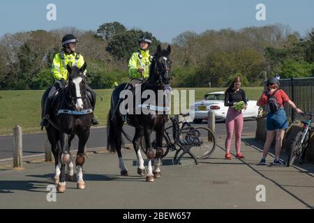 Die Polizistinnen der Avon & Somerset Constabulary, die sich auf Personen bewegen, die während des Coronvirus auf einer Bank in Durdham Downs, Bristol sitzen Stockfoto