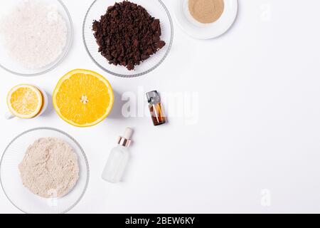 Natürliche hausgemachte kosmetische Zutaten für die Herstellung von Körper Peeling aus gemahlenem Kaffee, Meersalz, Ton, ätherisches Öl und frischen Zitrusfrüchten, flach legen. Stockfoto