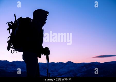 Junge Frau, die während des Sonnenaufgangs in Montana auf dem Gipfel des Berges steht Stockfoto