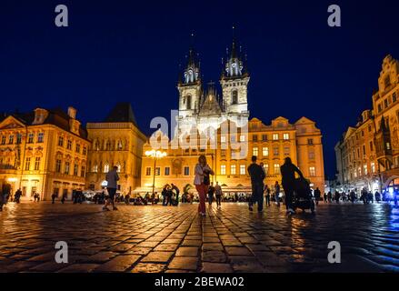 Touristen besichtigen spät in der Nacht auf dem Altstädter Ring unter den beleuchteten Türmen unserer Lieben Frau vor der Tyn Kirche in Prag, Tschechische Republik. Stockfoto