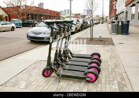 Denver, Colorado - 15. April 2020: Ungenutzte Lyft-Roller auf einer ruhigen Straße im Rino District während Covid-19 Aufenthalt zu Hause bestellen. River North Arts Stockfoto