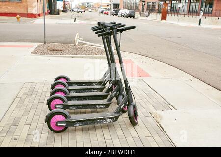 Denver, Colorado - 15. April 2020: Ungenutzte Lyft-Roller auf einer ruhigen Straße im Rino District während Covid-19 Aufenthalt zu Hause bestellen. River North Arts Stockfoto