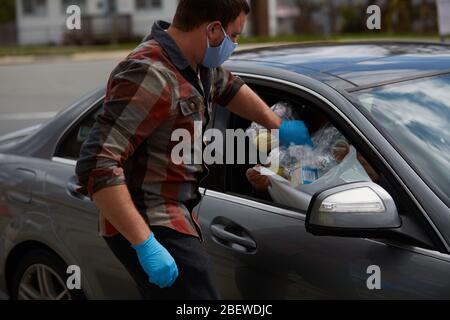 Chelsea, Massachusetts, USA. April 2020. Chelsea, Massachusetts, ist der am stärksten betroffenen Bereich des Staates während COVID-19, Corona Virus. Eine überwiegend lateinamerikanische Gemeinschaft, die sich den Luxus sozialer Distanz nicht leisten kann. Die Stadt hat eine Bevölkerung von 40,000 Menschen in einem 2 Quadratmeilen Radius. 80% der Bevölkerung gelten als wichtige Arbeitskräfte, wie Supermarktmitarbeiter, Transitmitarbeiter usw. das Chelsea-Schulsystem verteilt täglich Frühstück und Mittagessen an Bedürftige. Die Lebensmittel werden durch ein Autofenster übergeben. Kredit: Allison Dinner/ZUMA Wire/Alamy Live News Stockfoto
