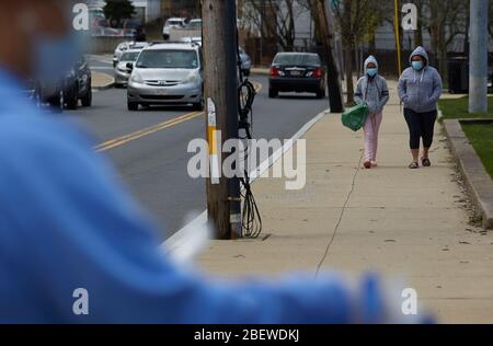 Chelsea, Massachusetts, USA. April 2020. Chelsea, Massachusetts, ist der am stärksten betroffenen Bereich des Staates während COVID-19, Corona Virus. Eine überwiegend lateinamerikanische Gemeinschaft, die sich den Luxus sozialer Distanz nicht leisten kann. Die Stadt hat eine Bevölkerung von 40,000 Menschen in einem 2 Quadratmeilen Radius. 80% der Bevölkerung gelten als wichtige Arbeitskräfte, wie Supermarktmitarbeiter, Transitmitarbeiter usw. das Chelsea-Schulsystem verteilt täglich Frühstück und Mittagessen an Bedürftige. Menschen, die gehen, um Essen zu sammeln. Kredit: Allison Dinner/ZUMA Wire/Alamy Live News Stockfoto
