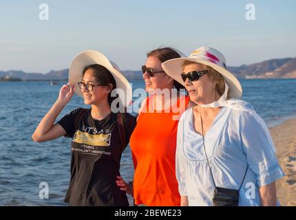 Drei Latinas Mexikanerinnen genießen den Sonnenuntergang am Strand, Tochter, Mutter und Oma, drei Generationen hängen am Strand. Stockfoto