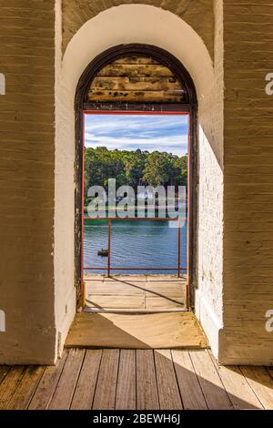 Blick auf den Hafen durch den Torbogen des Wehrturm in Port Arthur in Tasmanien, Australien. Stockfoto