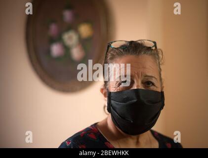 Malaga, Spanien. April 2020. Araceli Hernández, eine Freiwillige einer altruistischen Gruppe namens "Malaga hilft Krankenhäusern", posiert für ein Foto mit einer Gesichtsmaske in ihrem Haus, um Ärzten und Krankenschwestern bei der Coronavirus-Epidemie COVID-19 zu helfen. "Malaga hilft Krankenhäusern" ist eine gemeinnützige Gruppe von 58 Personen, die Sanitärmaterial als Schutzmaske oder weiße Mäntel aus Baumwolle nähen. Dieses Material wird an Krankenhäuser und das Gesundheitswesen verteilt. Quelle: SOPA Images Limited/Alamy Live News Stockfoto