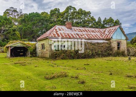 Ein verlassenes, Pionierbauernhaus auf einem Hügel an der Tasmanischen Ostküste in Australien. Stockfoto