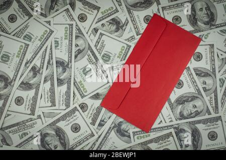 Chinesische leere rote Umschlag oder Hong Bao auf einer Gruppe von Geldstapel von 100 US-Dollar Banknoten viel von dem Hintergrund Stockfoto
