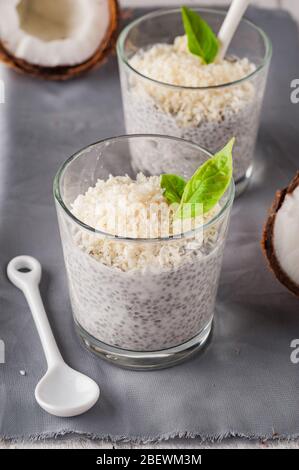 Chia Pudding mit Kokosnuss auf einer grauen Serviette. Zwei Gläser Chia Pudding. Gesunde Ernährung Stockfoto
