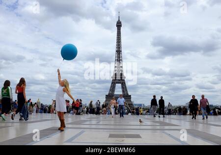 Ein junges Mädchen, das einen blauen Ballon am Place du Trocadero mit Eiffelturm im Hintergrund hält.Paris.Frankreich Stockfoto