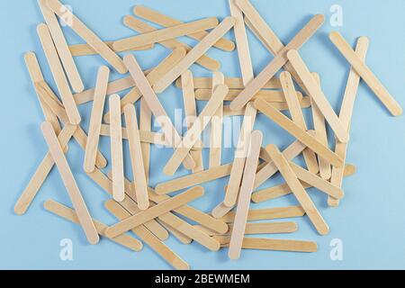 Holzeisstab auf blauem Hintergrund. Ein Haufen der Holzstäbe. Eisstock Stockfoto