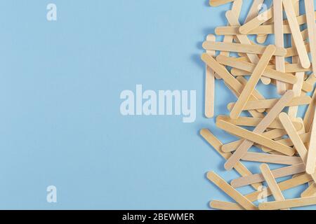 Holzeisstab auf blauem Hintergrund. Ein Haufen der Holzstäbe. Eisstock Stockfoto