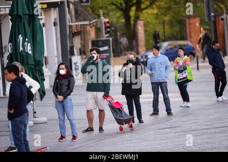 Brüssel, Begium. April 2020. Bürger warten auf einen Supermarkt in Brüssel, Begium, 14. April 2020. Die belgische Premierministerin Sophie Wilmes kündigte am Mittwoch eine Verlängerung der Sperre bis zum 3. Mai an, um die Ausbreitung des Coronavirus zu verhindern. Kredit: Zhang Cheng/Xinhua/Alamy Live News Stockfoto