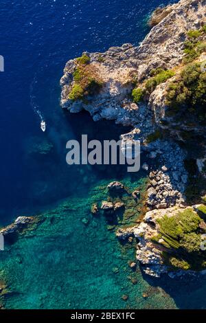 Abgeschiedene Lagune in mediterraner Meeresantenne. Schöne Bucht in Griechenland mit einem Boot herumschwimmend Stockfoto