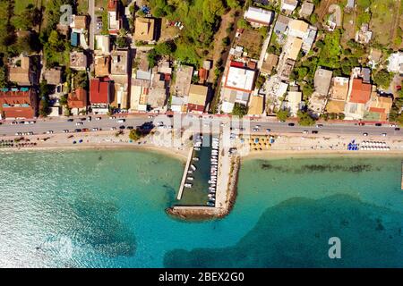 Antenne des mittelmeerstands in Griechenland. Kato Agios Markos Resort von einer Drohne. Wunderschönes türkisfarbenes Wasser und Strand mit Sonnenschirmen Stockfoto