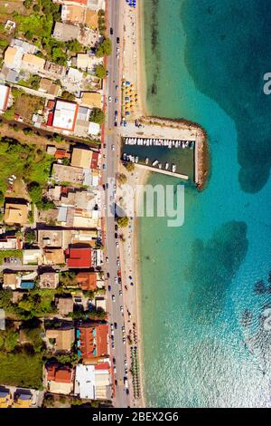 Luftbild des mediterranen Resorts in Griechenland. Touristen an einem griechischen Strand. Sonniger Tag und wunderschönes türkisfarbenes Meerwasser. Stockfoto