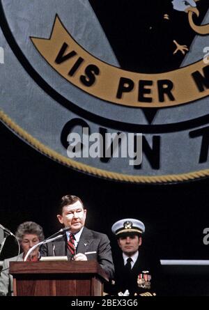 1982 - Senator John Tower, R - Texas, spricht während der Inbetriebnahme Zeremonie für die Atom-Flugzeugträger USS CARL VINSON (CVN-70). Sitzt hinter ihm sind CAPT Richard L. Martin, kommandierender Offizier der Carl Vinson, und Molly Snead, das Schiff ist Sponsor. Stockfoto