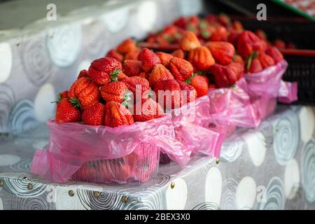 Reife Erdbeeren liegen in Tabletts, einem Slide Counter, auf dem Markt Stockfoto