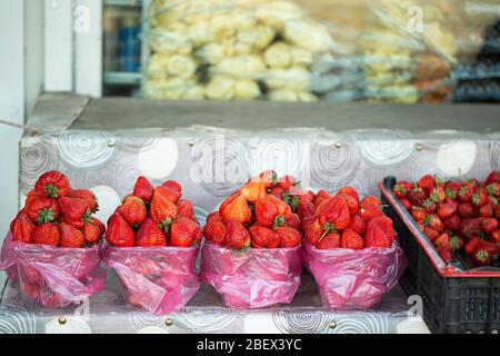 Reife Erdbeeren liegen in Tabletts, einem Slide Counter, auf dem Markt Stockfoto