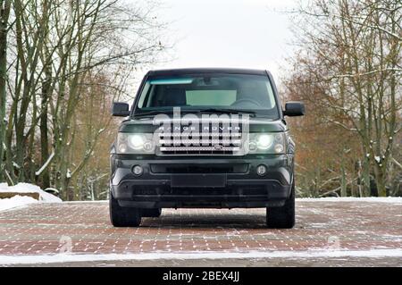 Grodno, Weißrussland, Dezember 2012: Land Rover Range Rover Sport V8 Supercharged. Vorderansicht des schwarzen SUV, über nicht scharf Winter forect Hintergrund mit Stockfoto