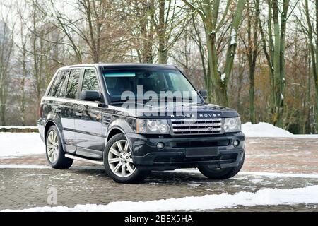 Grodno, Weißrussland, Dezember 2012: Land Rover Range Rover Sport V8 Supercharged. Drei vierte Ansicht des schwarzen SUV über dem Hintergrund des Winterparks, der nicht scharf ist, Stockfoto